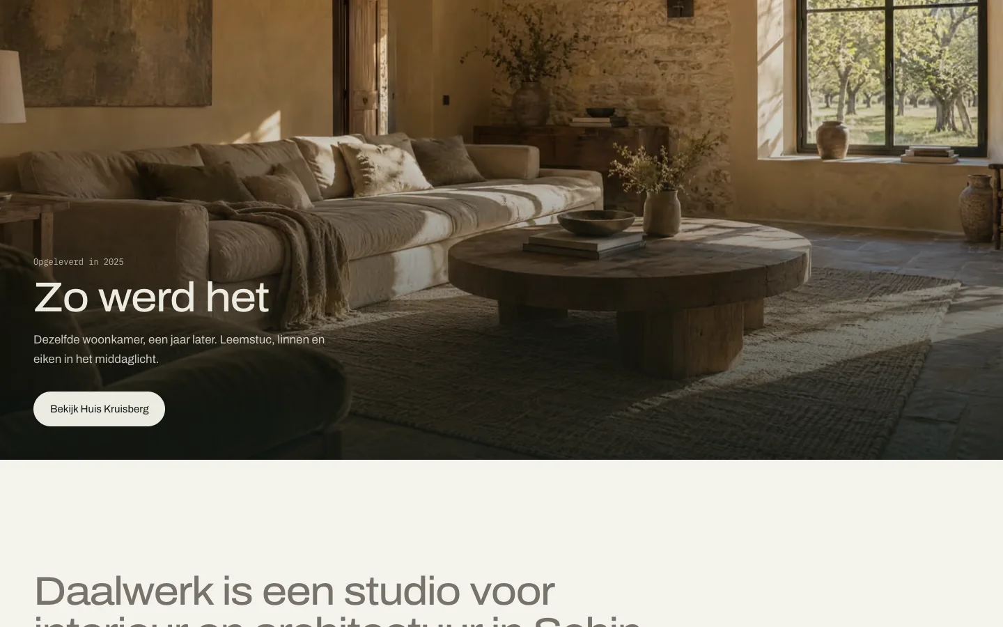 The same living room as a photograph, a year later: loam plaster, linen and oak in afternoon light